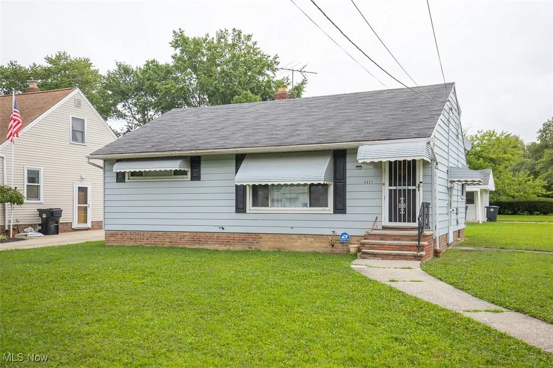 View of front of home featuring a front yard, a chimney, and roof with shingles