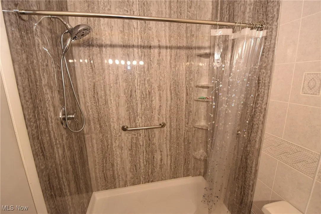 Full bathroom featuring a shower stall