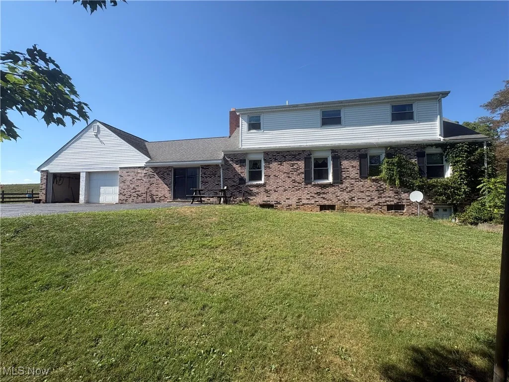 View of front of house featuring a garage, crawl space, a front lawn, and gravel driveway