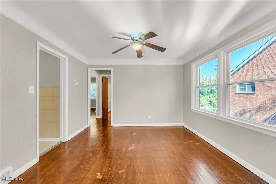 Unfurnished room with hardwood / wood-style floors and a ceiling fan
