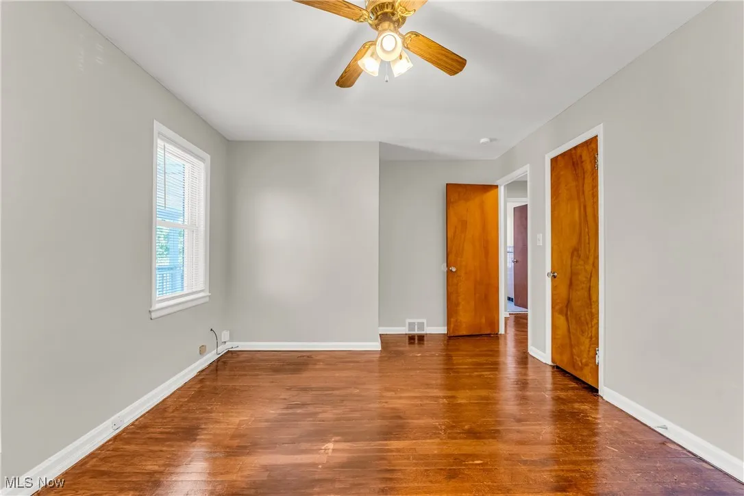 Empty room featuring wood finished floors and a ceiling fan