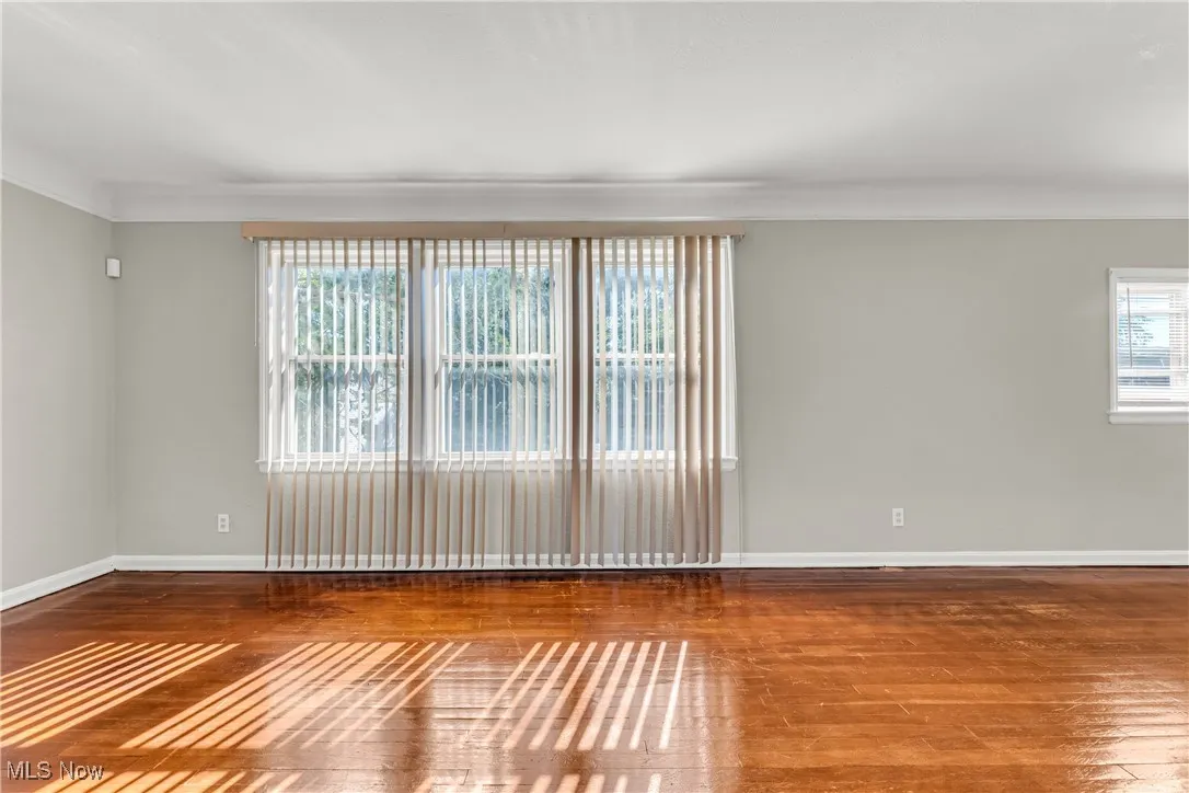 Unfurnished room featuring hardwood / wood-style flooring and crown molding