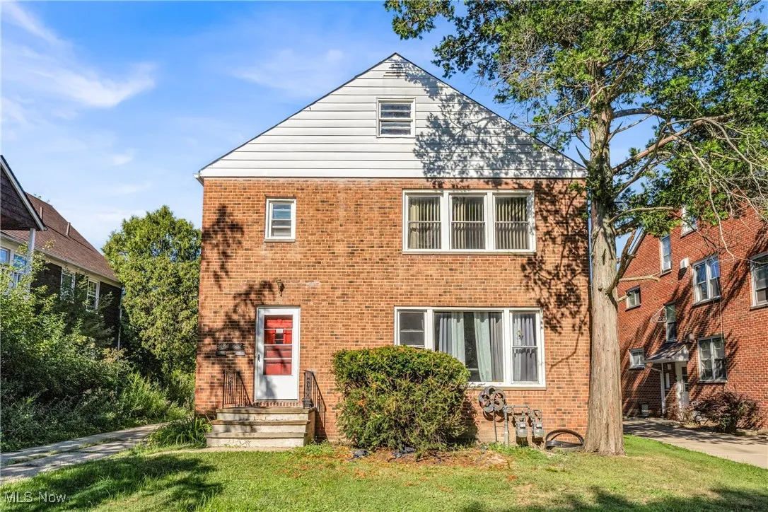 View of front of home featuring a front lawn and brick siding