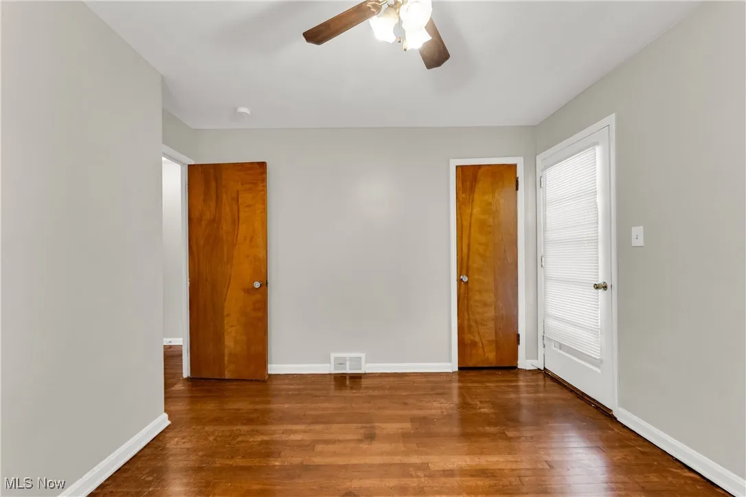 Unfurnished bedroom with dark wood-style flooring and ceiling fan