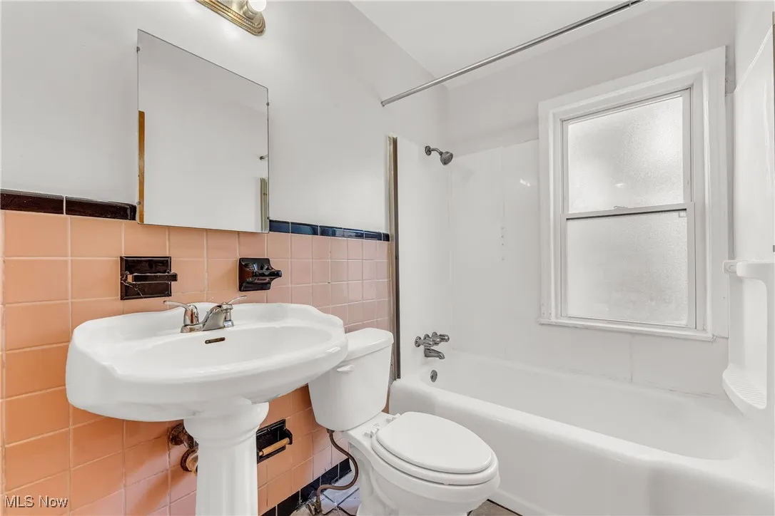 Full bath with bathtub / shower combination and tile walls