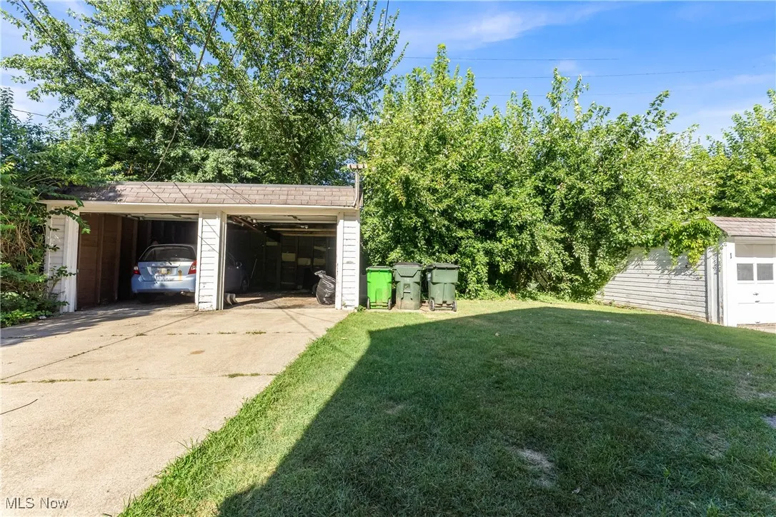View of grassy yard featuring an outdoor structure and a garage