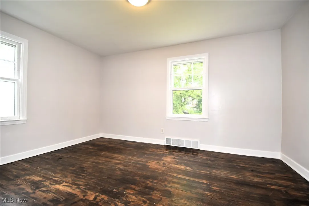 Spare room featuring dark wood-type flooring