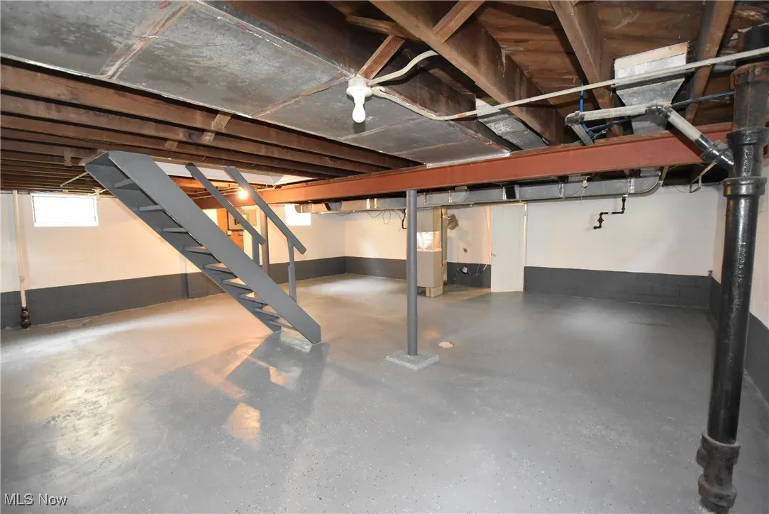 Below grade area featuring stairs and heating unit