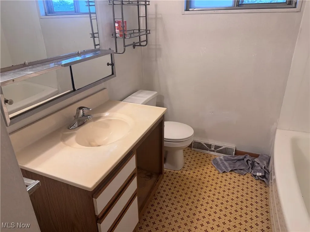 Full bathroom featuring vanity and toilet