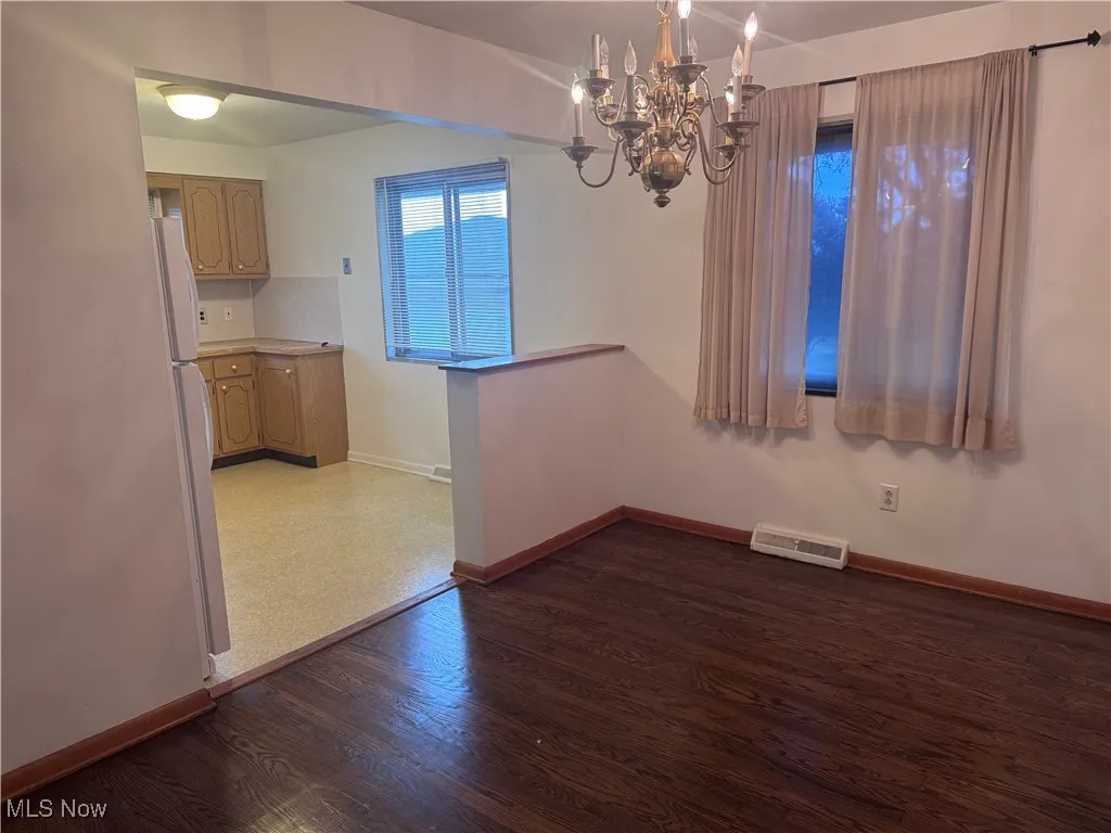 View of dining area looking into the kitchen with ceiling fan.