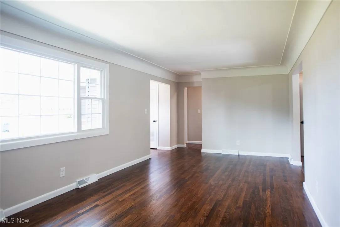 Spare room featuring dark wood-type flooring