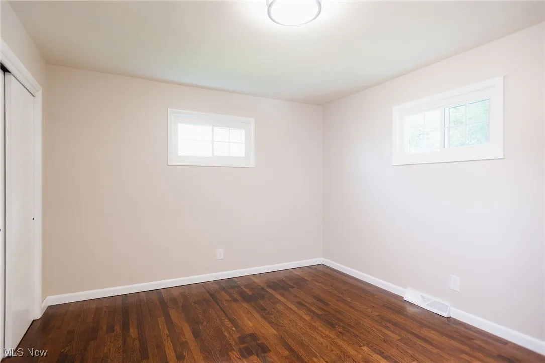 Unfurnished bedroom with a closet and dark wood-style floors