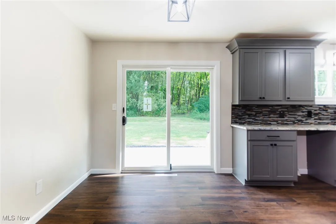 Unfurnished dining area with dark wood finished floors
