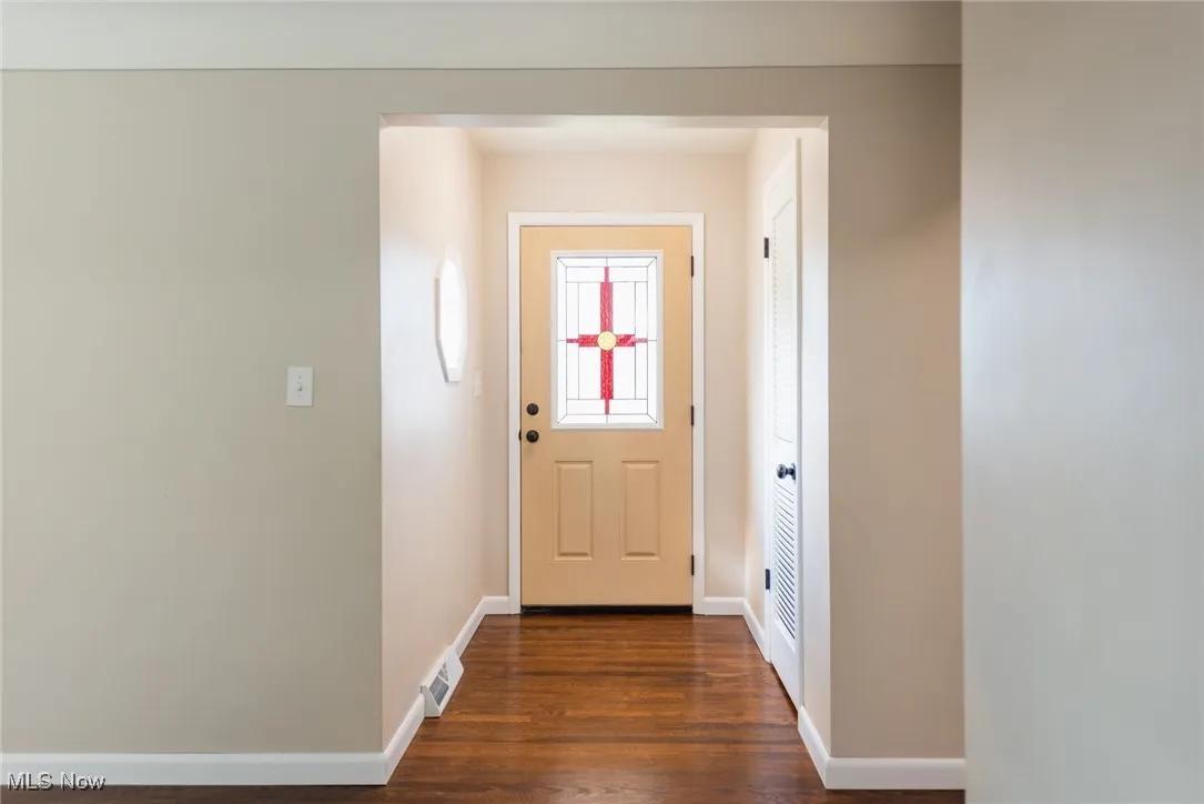 Doorway to outside with baseboards and wood finished floors