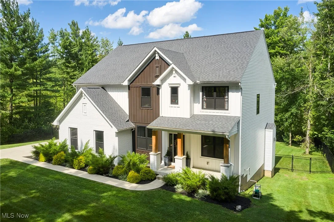 Modern farmhouse with board and batten siding, a porch, and a shingled roof