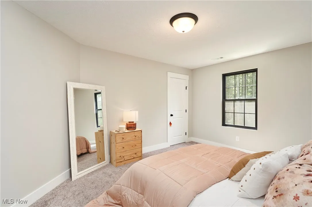 Carpeted bedroom featuring baseboards