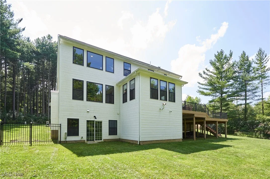 Back of property featuring stairway, a lawn, and a deck