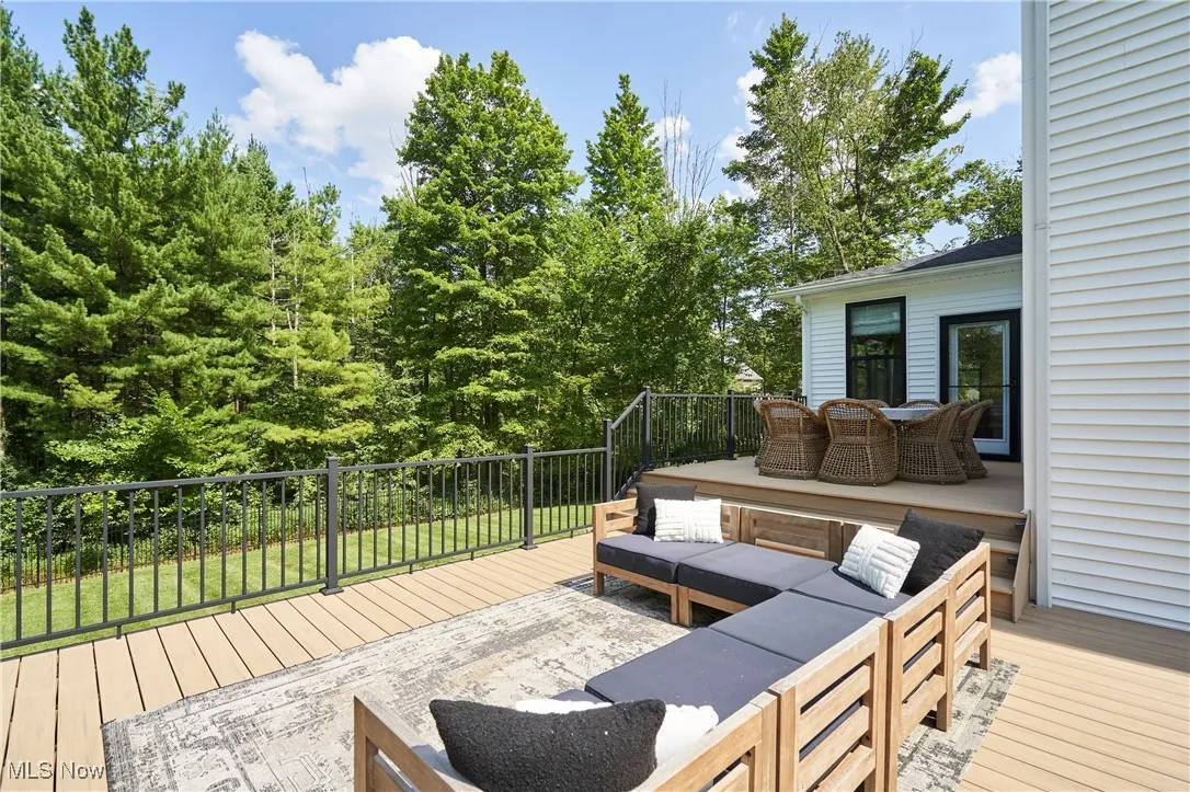 Wooden terrace with an outdoor living space and view of wooded area
