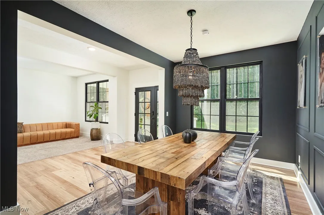 Dining area with light wood finished floors, a chandelier, and a textured ceiling