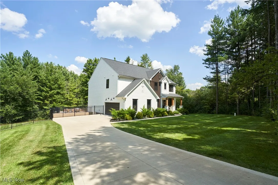 View of front of house with an attached garage, driveway, and covered porch