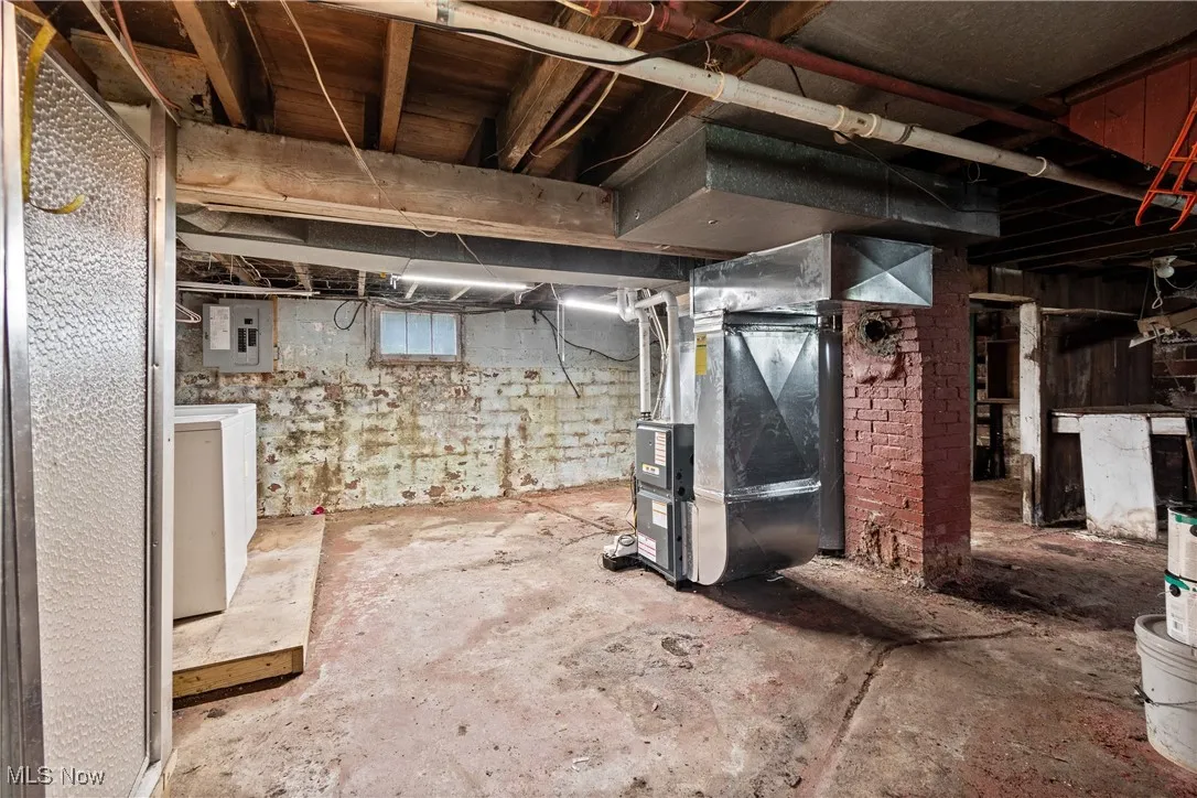 Basement featuring washer / dryer, heating unit, and electric panel