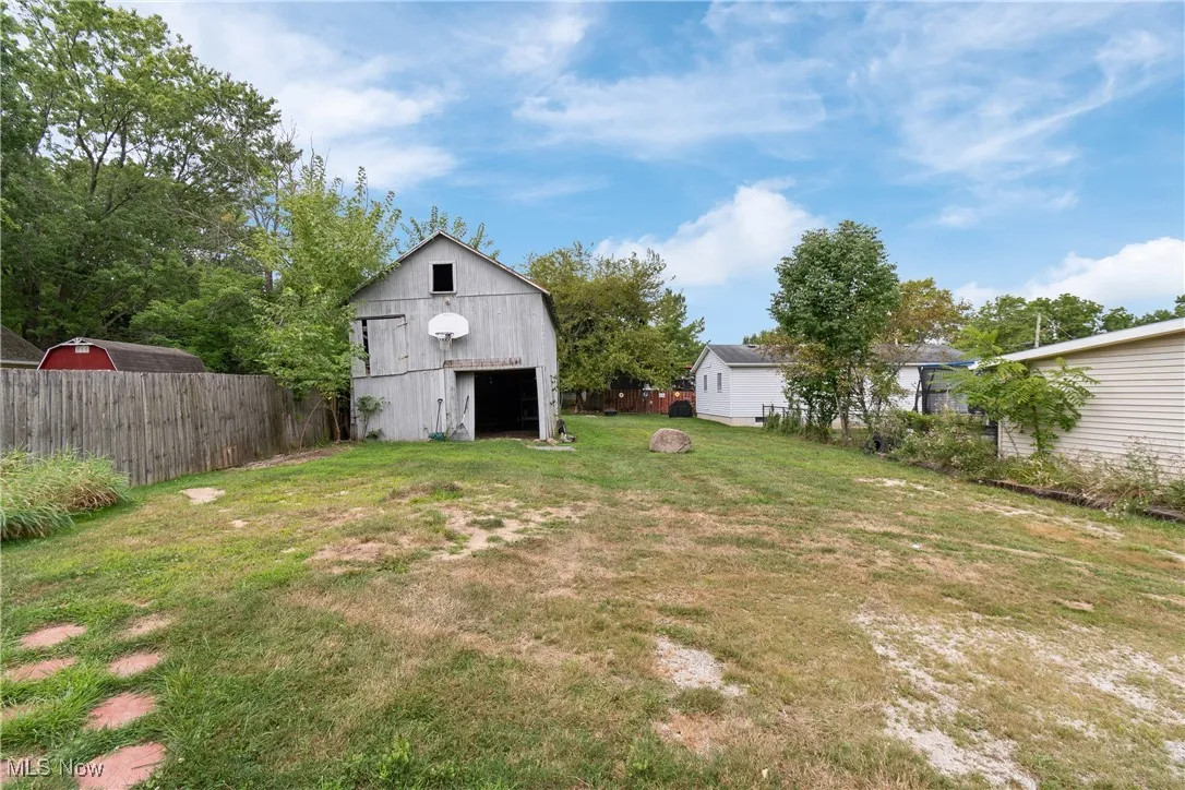 View of yard with an outdoor structure, a garage, and a barn