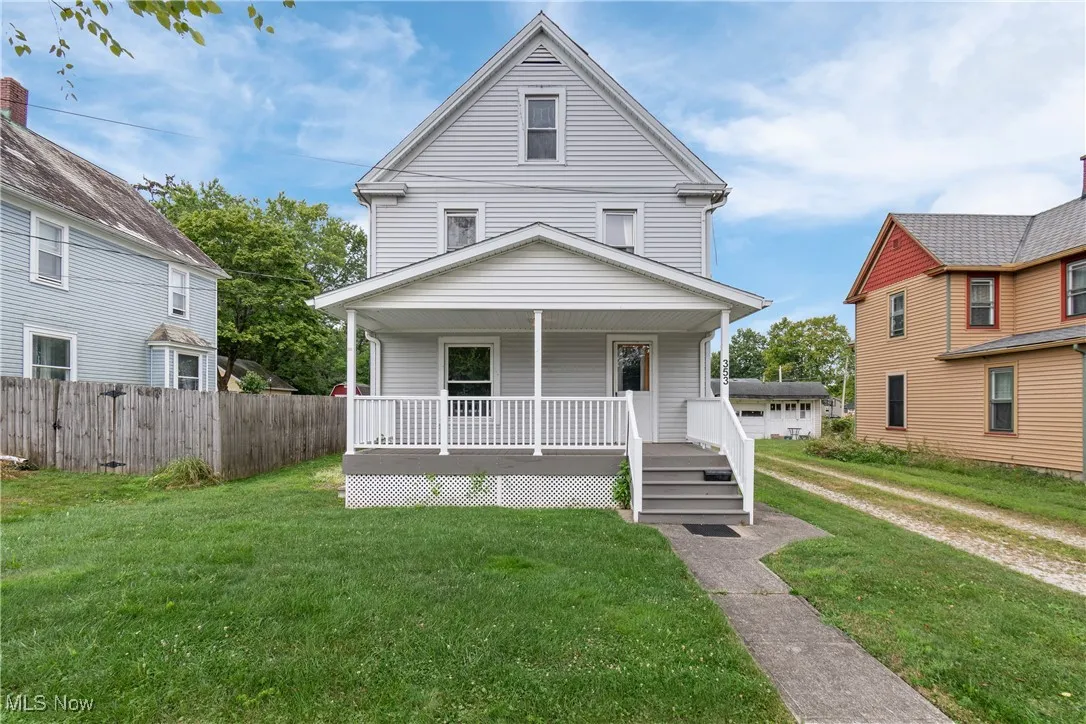 American foursquare style home with covered porch and a front lawn