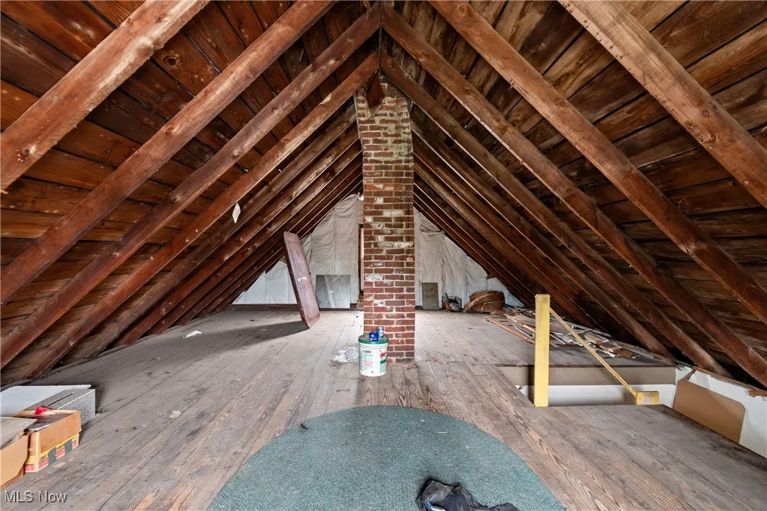 Unfinished attic with an upstairs landing