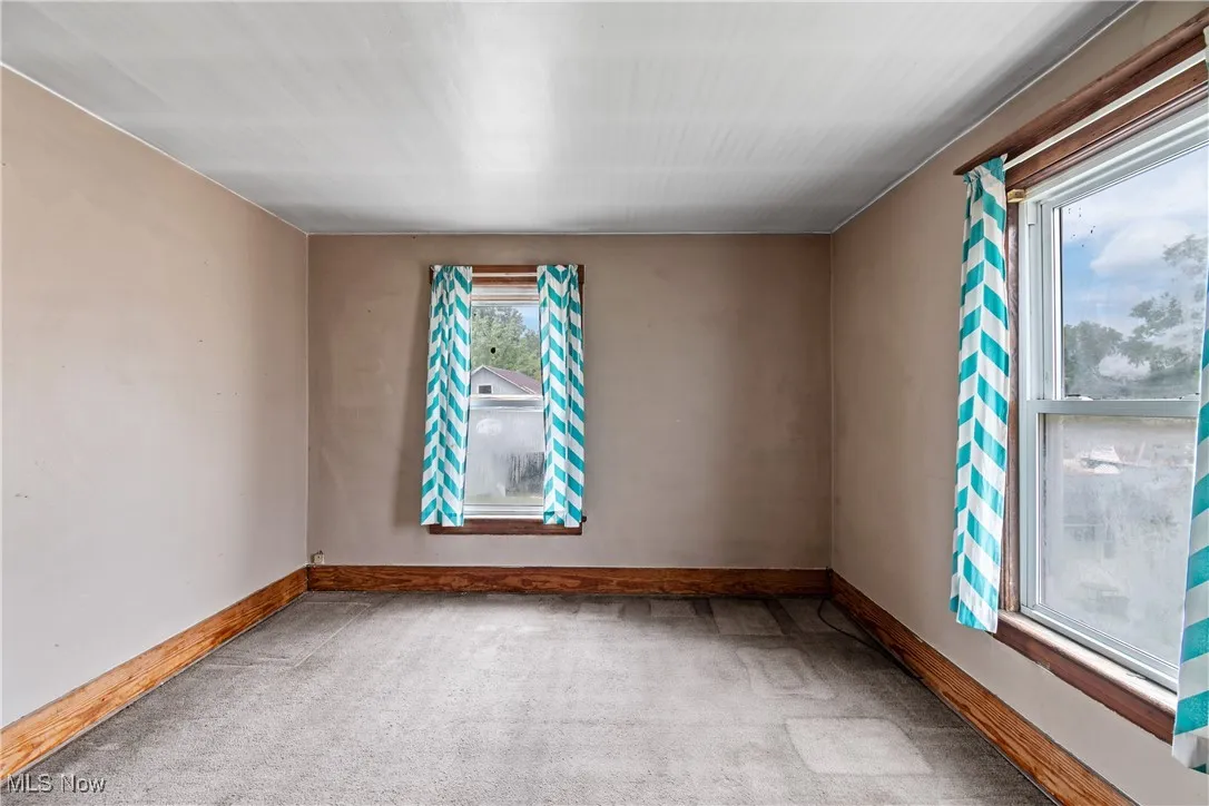 Empty room featuring carpet and baseboards