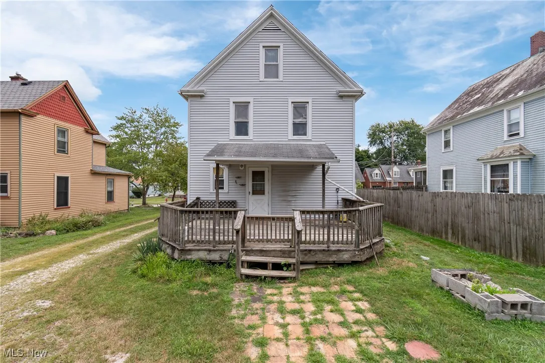 Back of property with a deck and a yard