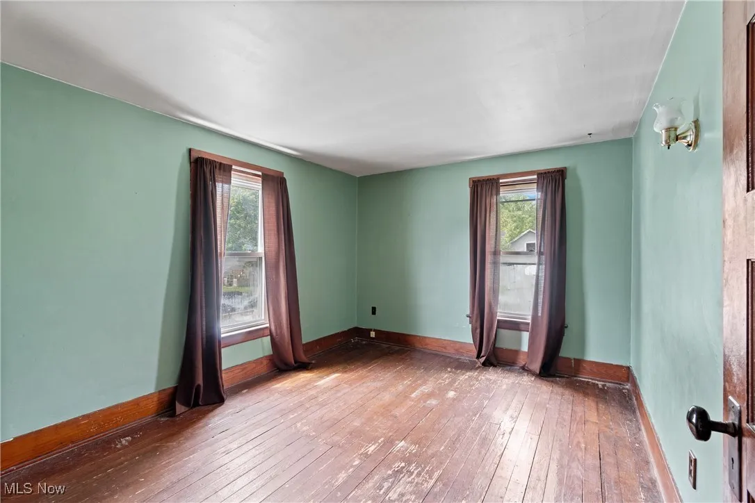 Unfurnished room with wood-type flooring and healthy amount of natural light