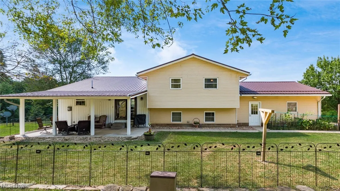 Back of property with a metal roof and a patio