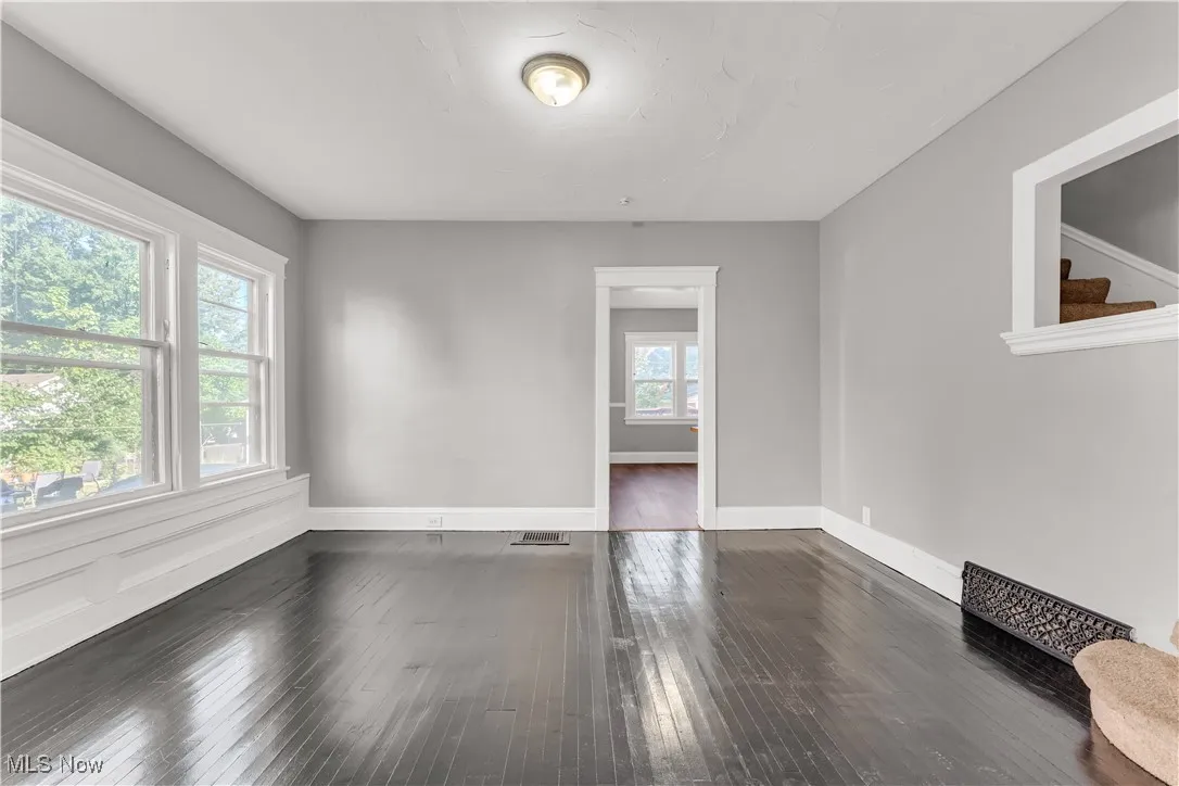 Empty room featuring dark wood finished floors and stairway
