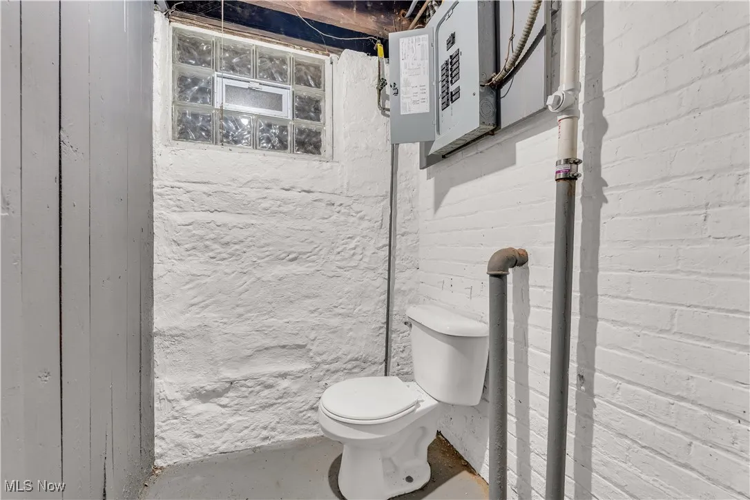 Bathroom featuring electric panel and concrete flooring