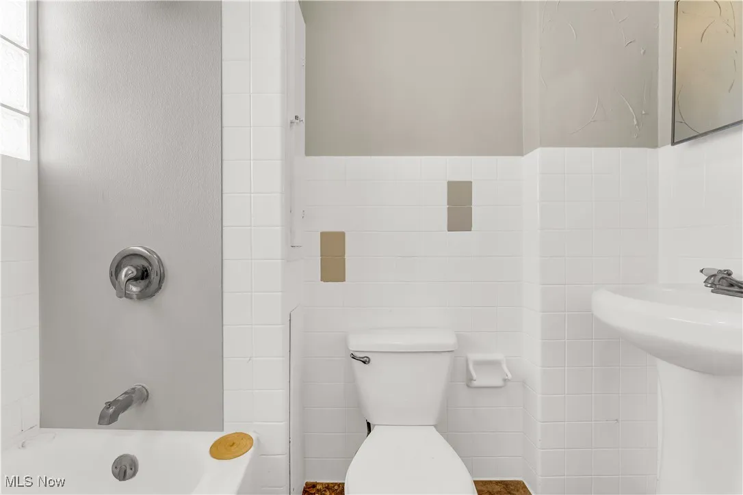 Bathroom featuring tile walls and  shower combination