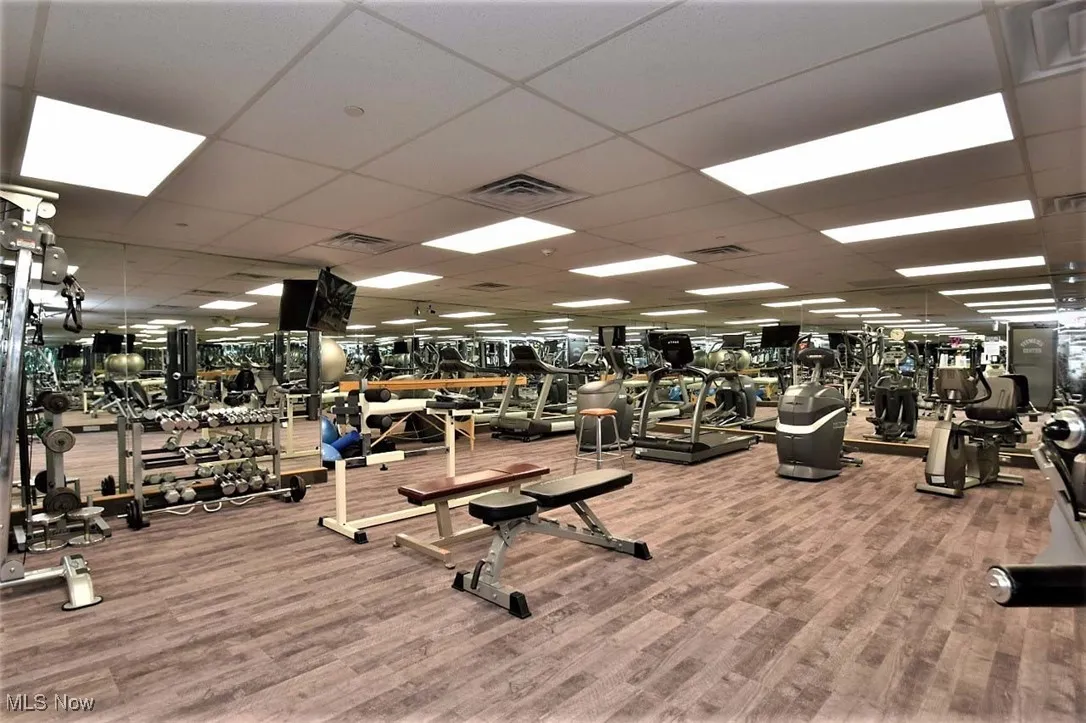 Gym with a drop ceiling and wood finished floors