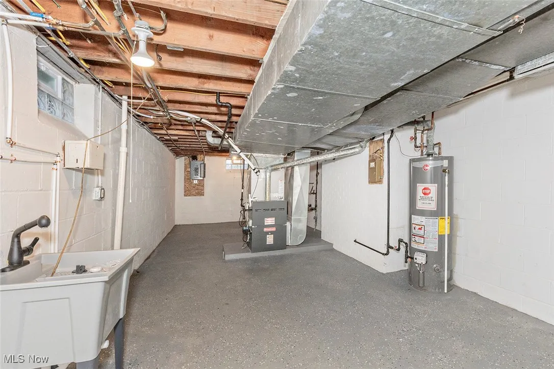 Unfinished basement featuring gas water heater and heating unit