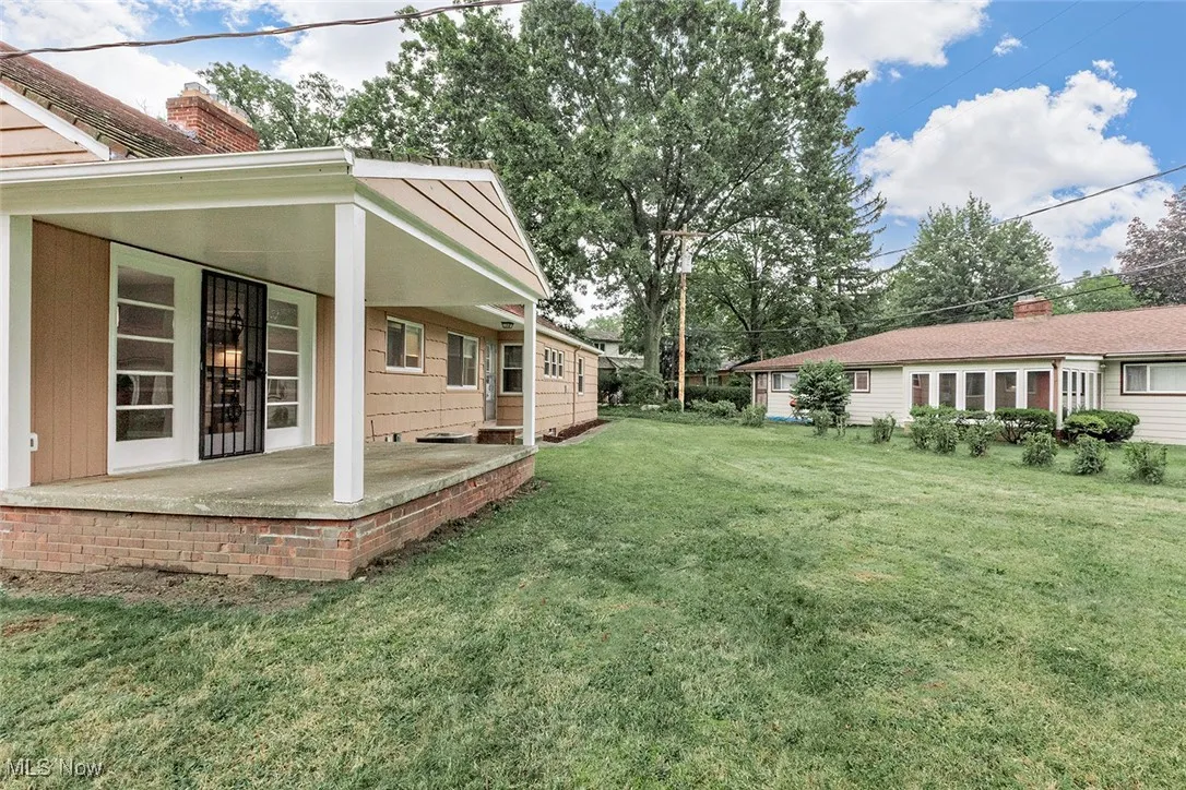 View of green lawn with covered porch