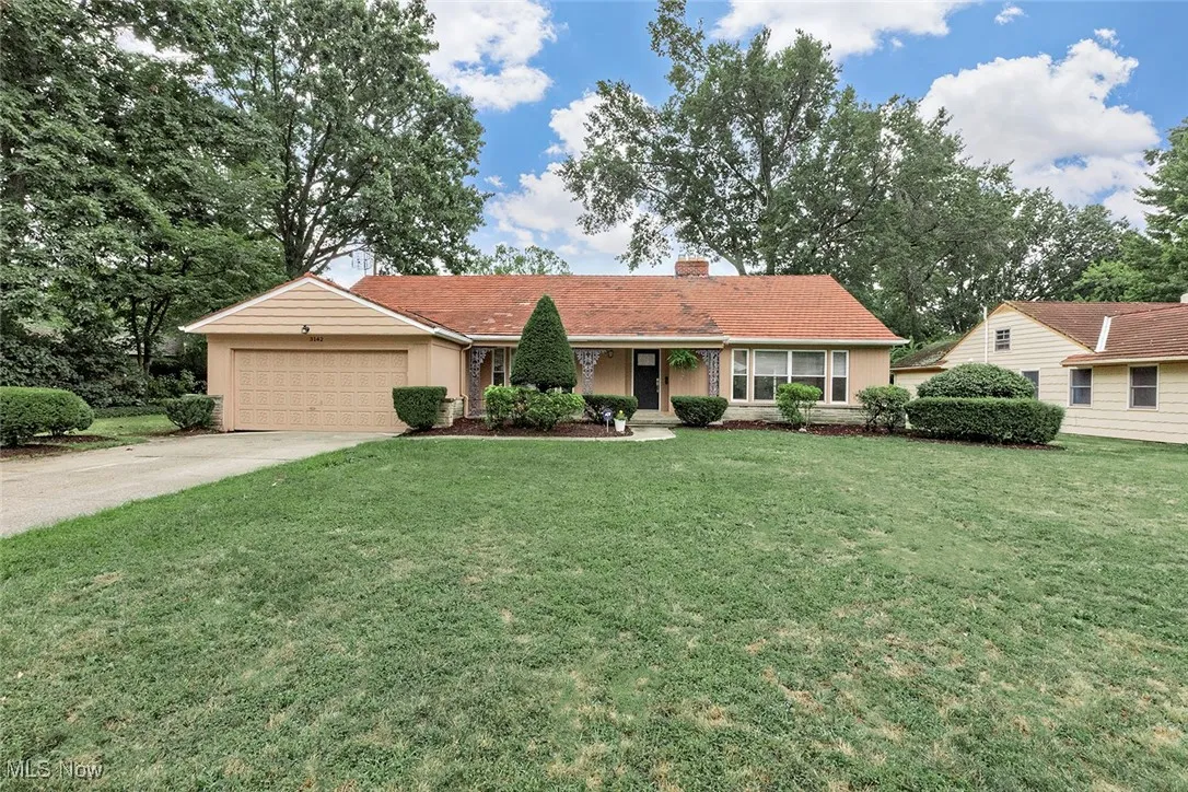 Single story home with an attached garage, a front yard, concrete driveway, and a chimney