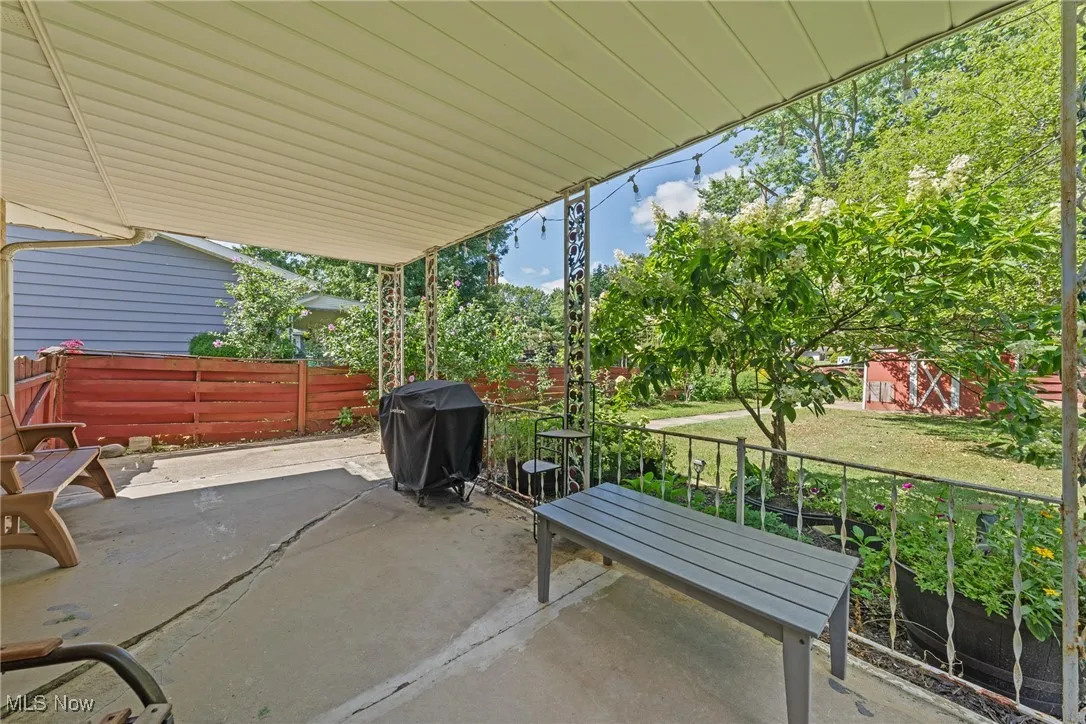 View of patio with a grill
