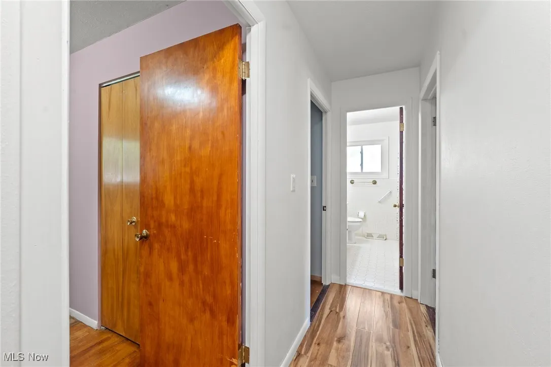 Corridor featuring wood finished floors and baseboards