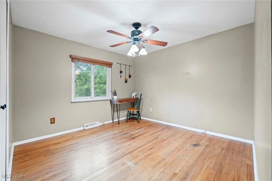 Bedroom/office with hardwood floors and ceiling fan