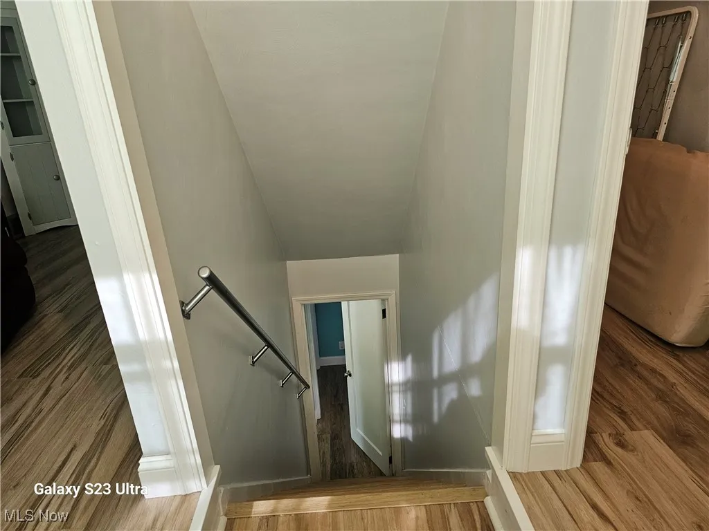 Staircase featuring wood finished floors and baseboards