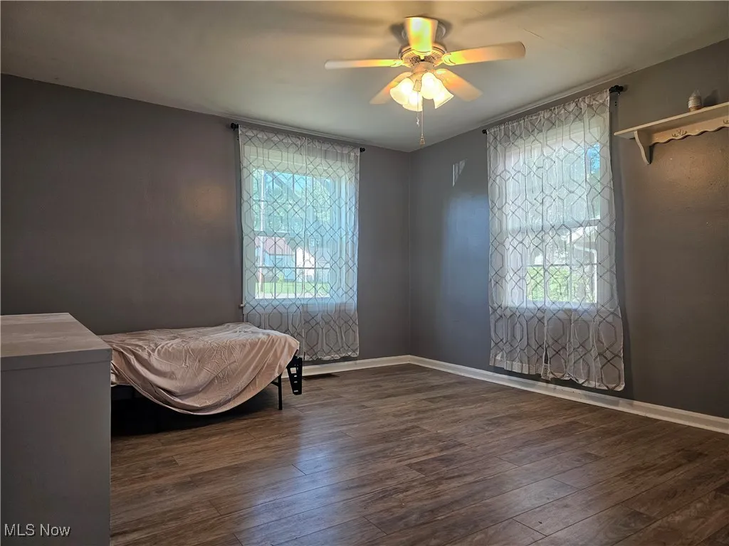Bedroom featuring dark wood-style flooring and a ceiling fan