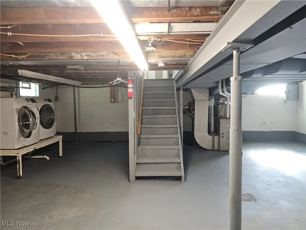 Below grade area with stairway, washing machine and clothes dryer, heating unit, and electric panel