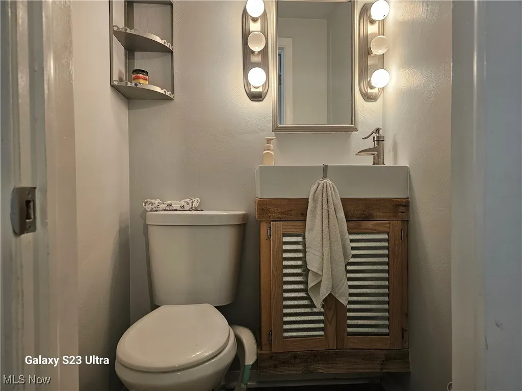 Half bath featuring vanity and a textured wall