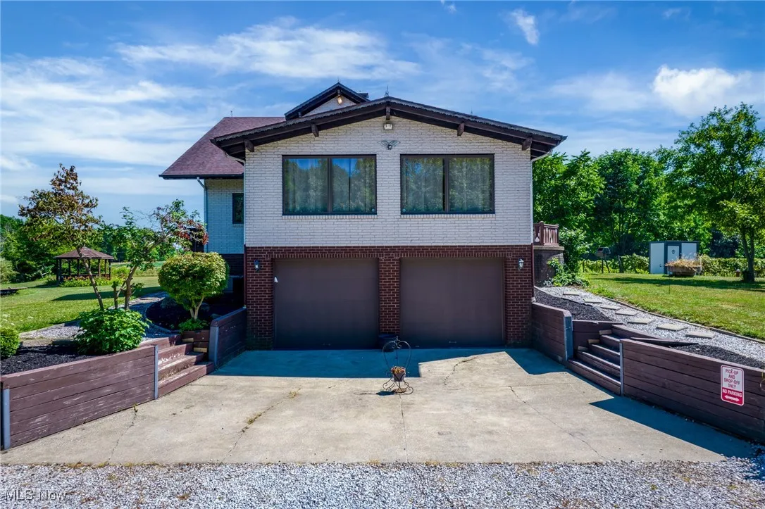 View of front of home with brick siding, concrete driveway, a front yard, and a garage