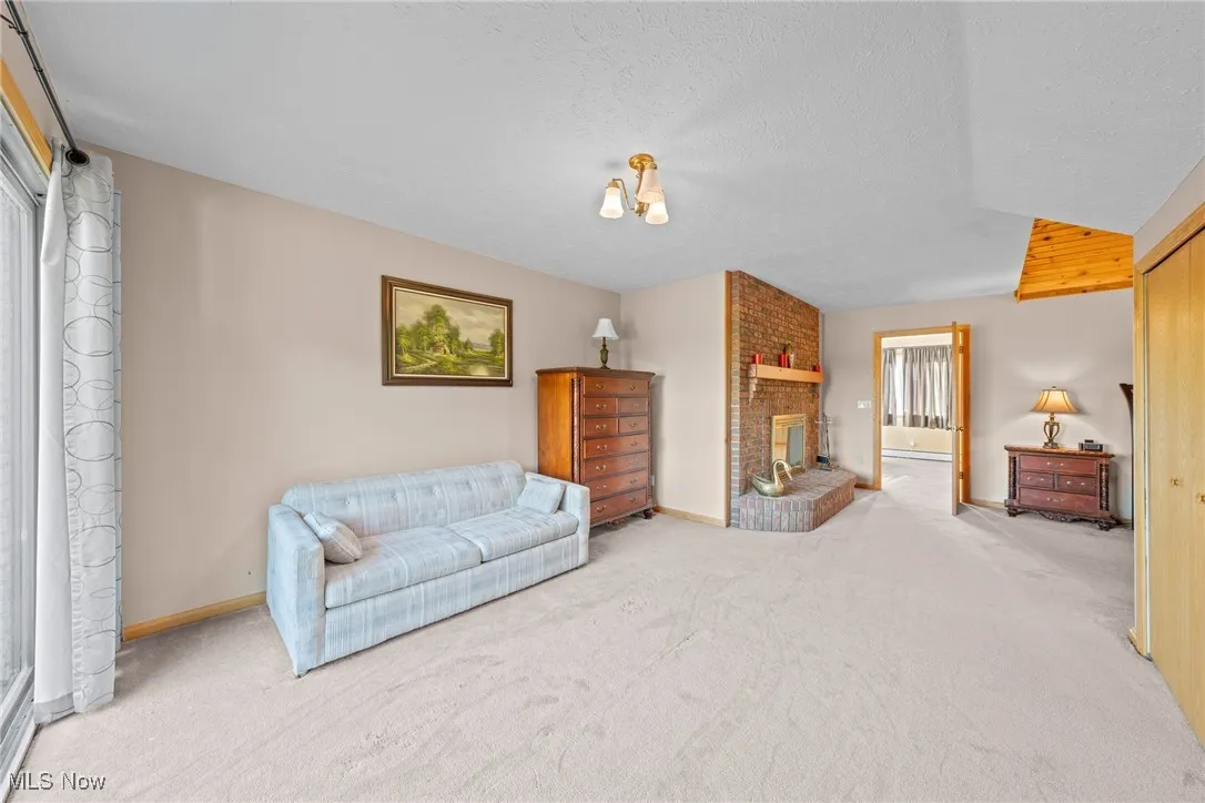 Living room with carpet floors, a fireplace, and a textured ceiling