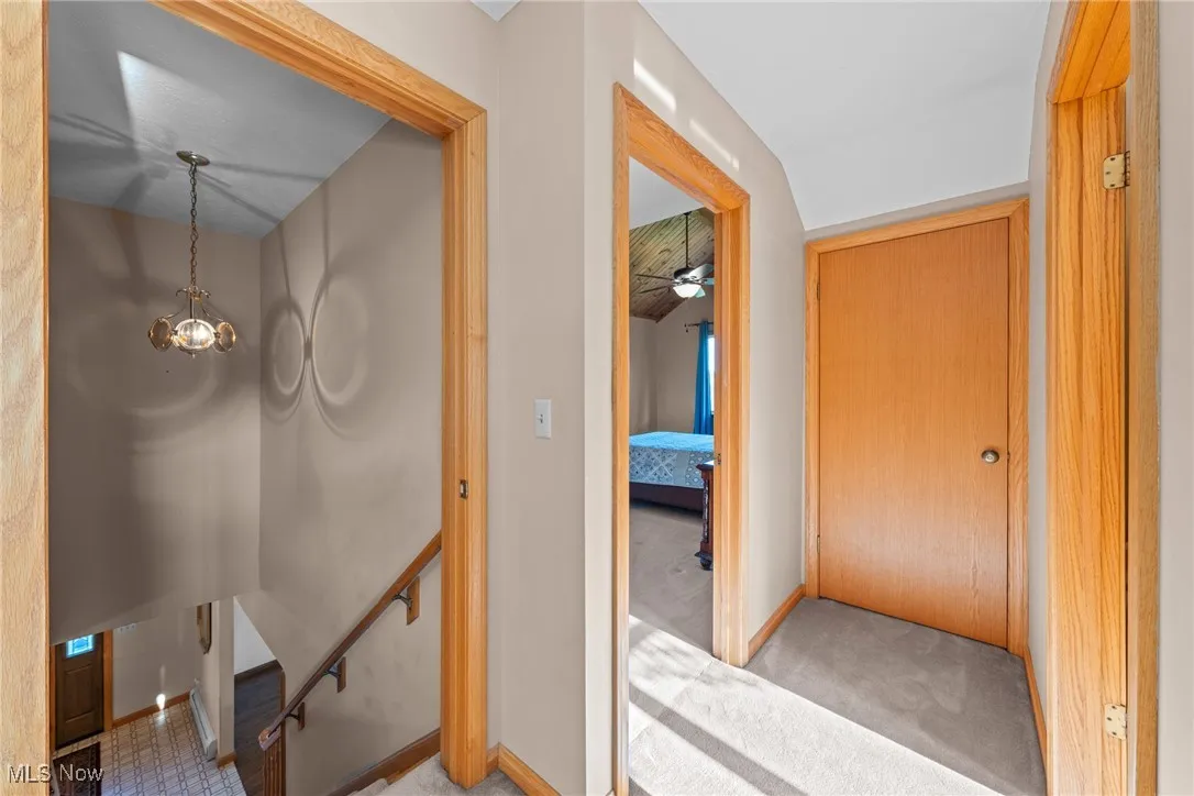 Hallway featuring an upstairs landing and carpet