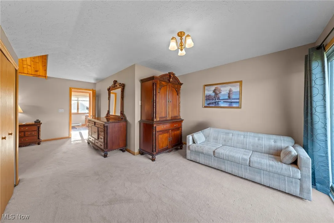 Living area with light colored carpet and a textured ceiling